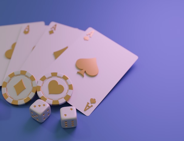 A set of playing cards displaying four aces is laid out on a surface. Alongside them, there are two poker chips with heart and diamond symbols, and three six-sided dice showing different numbers. The background is a smooth gradient of purple, creating a thematic gaming or casino atmosphere.